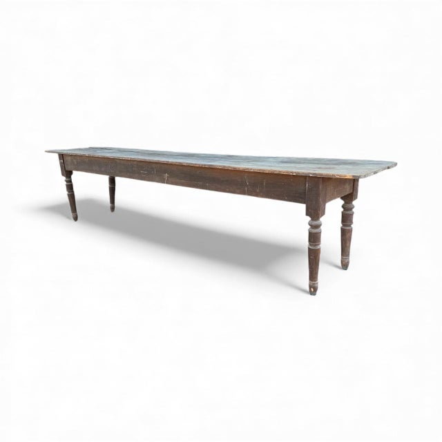 A remarkable early–1800s French farmhouse table featuring a long, narrow plank top and beautifully aged patina. Hand-...