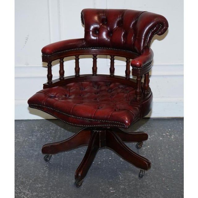 Fine 1950s Burgundy Chesterfield Leather Captain's Swivel Desk Chair. Exuding mid-century sophistication and timeless...