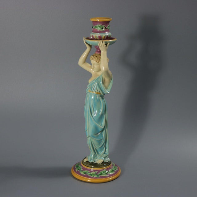 George Jones Majolica candlestick which features a lady dressed in a classical, flowing robe, holding the candle sconce...