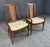 This pair of mid-century modern walnut arm chairs features gently curved frames with warm wood tones and tall cane back...