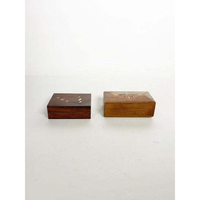 Pair of wooden boxes with decorative marquetry, France, 1970s. Set of two rectangular wooden boxes, each featuring an...