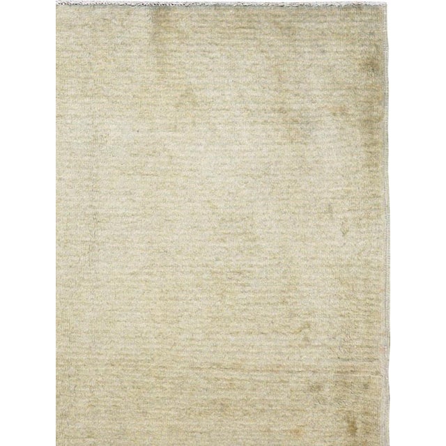 This mid-20th-century Turkish Anatolian rug presents an exceptionally restrained composition in soft ivory, pale beige,...