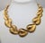 1982 goldtone graduated articulated textured heart shaped leaves collar necklace with fold over clasp. Marked "Napier" in...