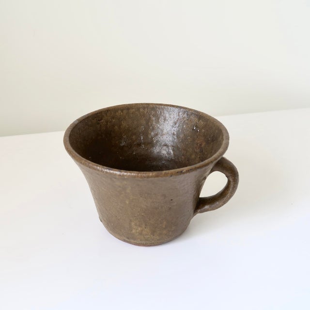 A beautifully understated handcrafted studio pottery vessel with an earthy brown glaze and sculptural flared form....