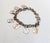 Late 1930s goldtone coat of arms charms bracelet with spring ring clasp. Marked "Monet Jewelers." Measures: 7.25 inches...
