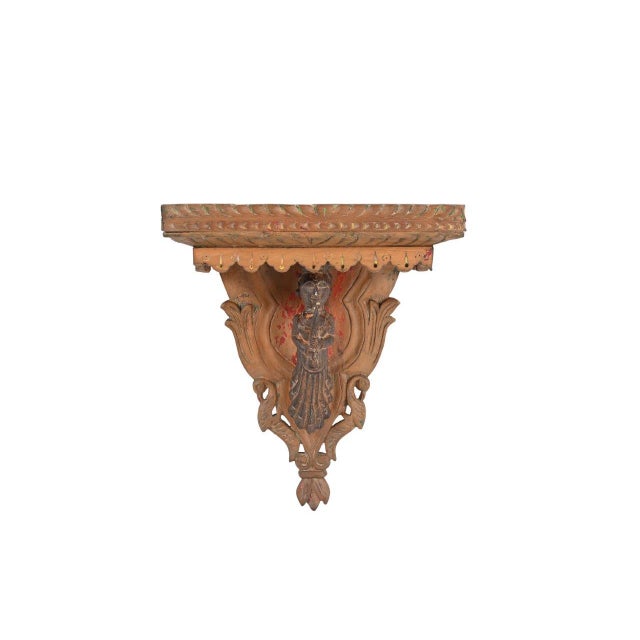 This Vintage Indian Carved and Painted Teakwood Wall Shelf is handcrafted from solid teakwood and embellished with...
