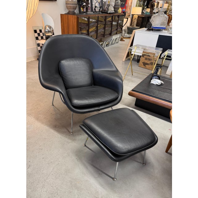 A beautiful black leather Eero Saarinen for Knoll Womb Chair and Ottoman. Both pieces retain their original labels. The...