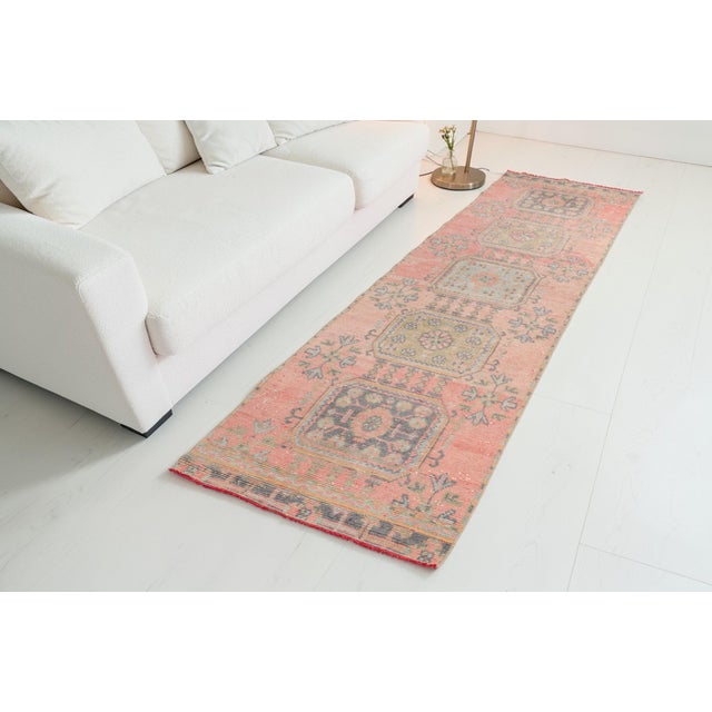 This is a vintage Turkish Oushak rug from the Mid 20th Century. The piece was hand-knotted.