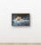 The work depicts a coastal scene with water crashing against rocks, featuring heavy texture or impasto brushwork.