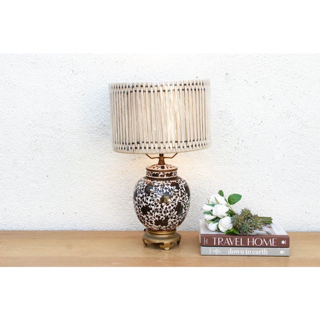 This striking table lamp is crafted from a vintage porcelain ginger jar featuring a bold, obsidian-and-white botanical...