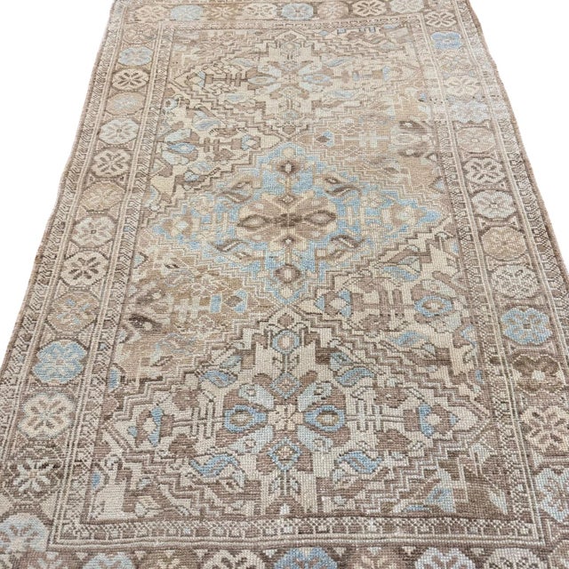 This elegant antique rug is defined by a simple and harmonious composition of three central medallions set against a...