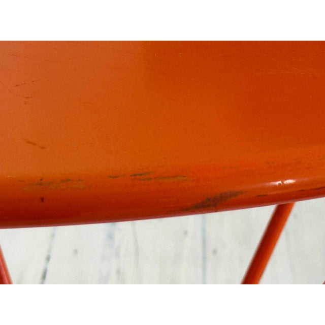 Vintage modern round orange enameled metal table.