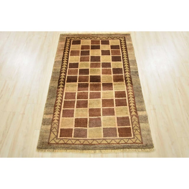 An authentic vintage tribal Gabbeh rug hand-knotted with fine wool and natural dyes. This nomadic oriental rug features a...