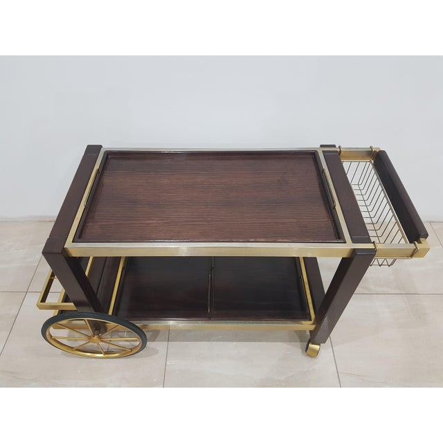 Signature chrome serving trolley with two small and one large tray, made of brown oak. The bar was designed and...