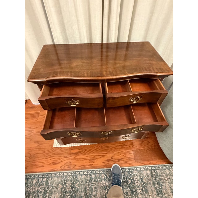 Rich wood tones, graceful curves, and intricate details give this vintage Henredon chest an elegant presence. Its...