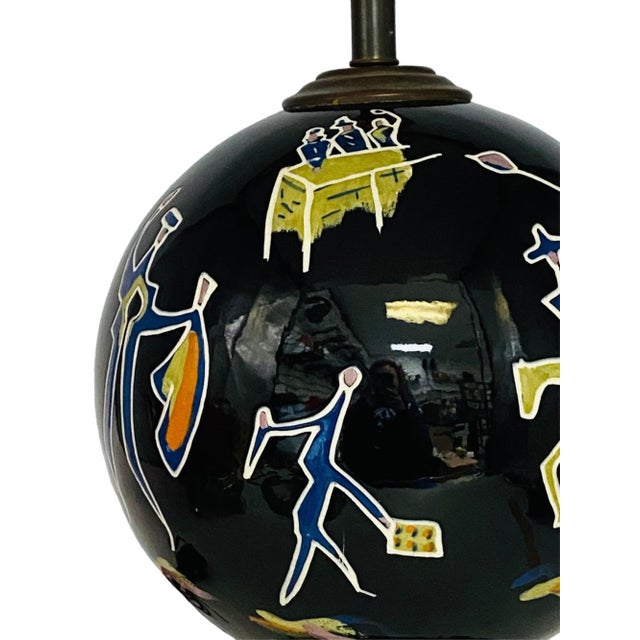 A Mid-Century black ceramic globe lamp by Tye of California. The lamp features Modernist figures depicting a bullfight on...