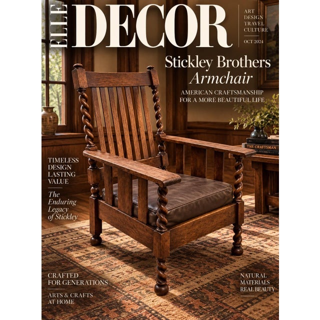 An oak armchair featuring a vertical slat back, flat wooden armrests, and pronounced barley twist uprights and legs...