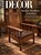 An oak armchair featuring a vertical slat back, flat wooden armrests, and pronounced barley twist uprights and legs...