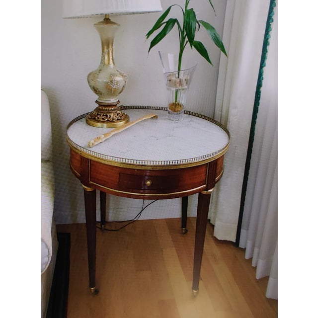 A unique 19th century Louis XVI Style mahogany round side table Bouillotte. Marble top, golden rail, two drawers and...