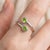 This modern and elegant open ring features vibrant Peridot gemstones, celebrated for their fresh green brilliance and...