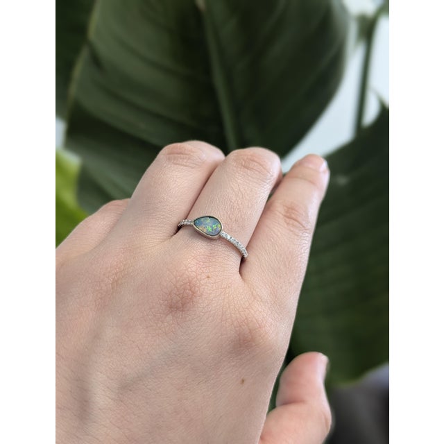 A slice of Australian magic. A dreamy 0.62 carat boulder opal takes center stage, framed by twinkling earth-mined diamonds...