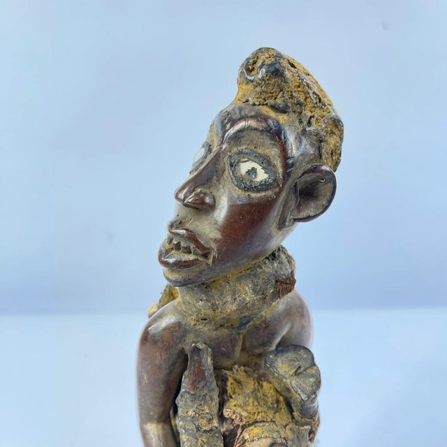 Experience the beauty and culture of Africa with our Kongo Seated Fetish Figure from Congo. Hand-carved from pigmented...