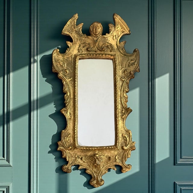 A late 19th century Italian Baroque Revival carved gilt wood wall mirror, circa 1880–1900. The vertically oriented frame...