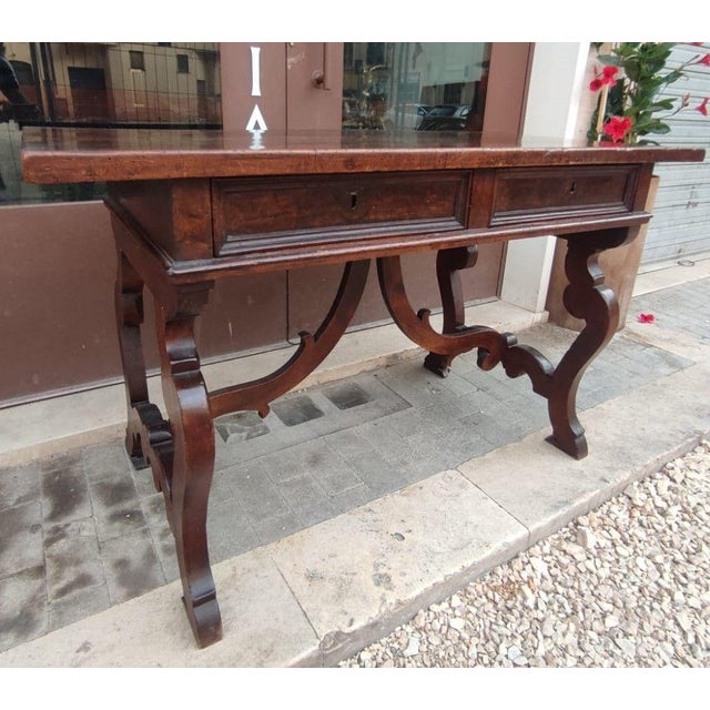 This important central writing table is entirely made of walnut wood and has an exceptional patina. The piece of...
