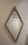 Mirror with a rare diamond shape and a burgundy and gold wooden frame.
