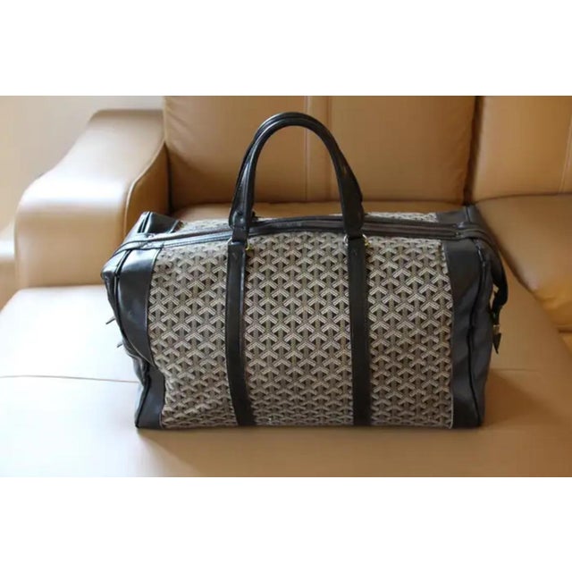 This very nice Goyard bag features the very famous Goyard chevrons woven canvas as well as many pieces of black color...