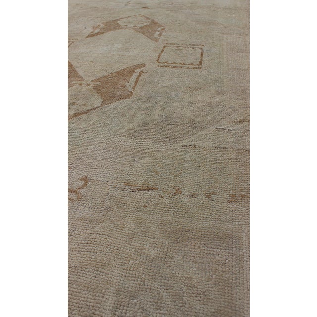 Measures: 3'4'' x 11'8''. This beautiful vintage Oushak runner from mid-20th century Turkey features a Classic geometric...