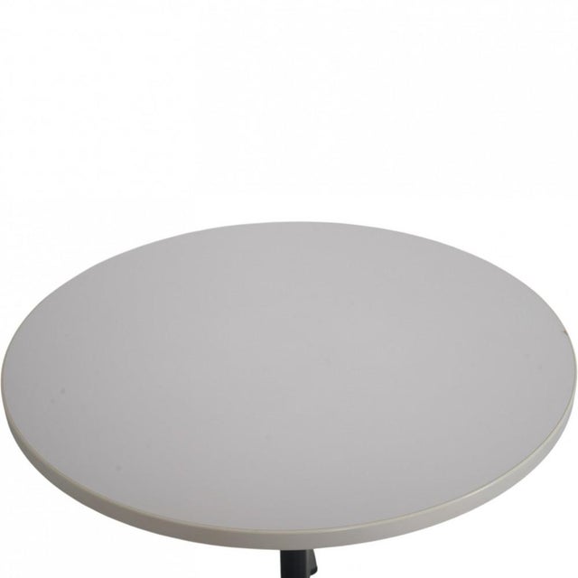 Charles Eames circular table with a white laminat table top and a chrome frame. The table is from the 2000s and appears in...