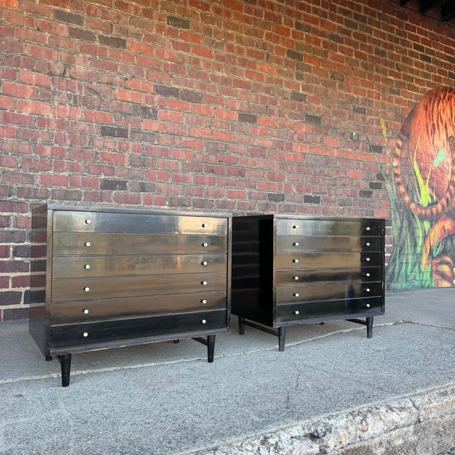 This pair of chest drawers by American of Martinsville are black painted wood with white vinyl tops. The drawer pulls are...