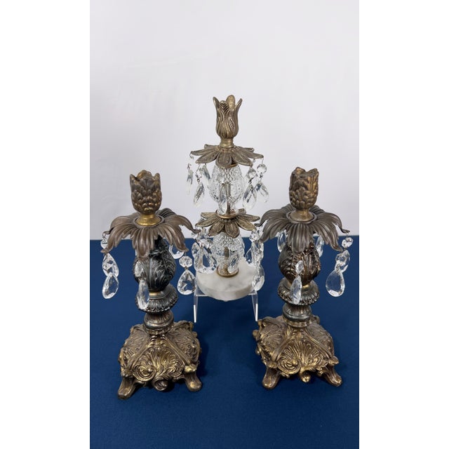 A commanding three-piece arrangement of Hollywood Regency girandoles. The centerpiece features tiered glass prisms draped...