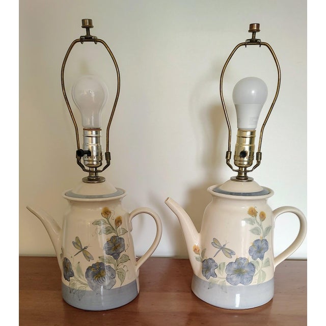 Lovely pair of Patton stoneware pottery lamps. The design features a teapot with dragonfly and blue flower pattern painted...
