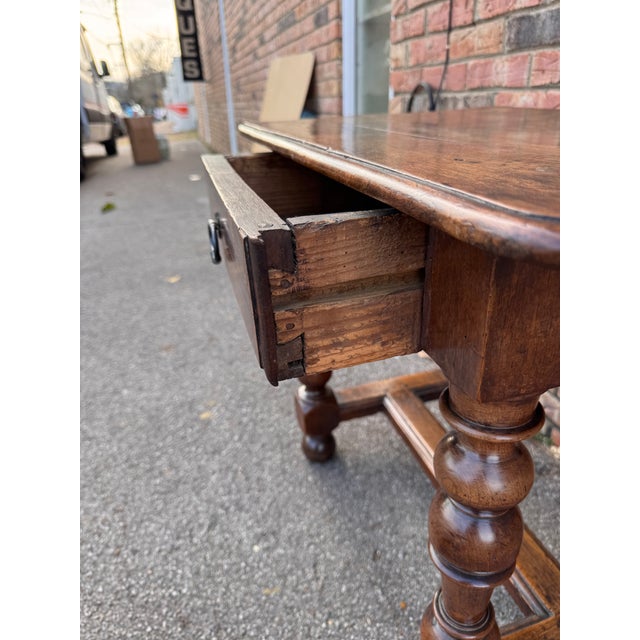 Charming c.1820 wooden side table featuring beautifully turned legs, a single drawer with metal pull, and a sturdy...