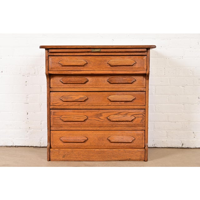 A gorgeous antique Arts & Crafts flat file or five-drawer chest of drawers with pull out writing desk In the manner of...