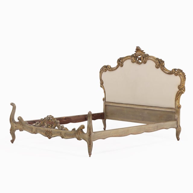 This elegant early 20th-century French Louis XV style bed features a richly carved wooden frame with scrolling rococo...