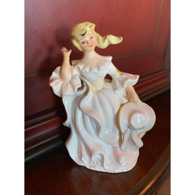 Royal Doulton Southern Belle Figurine holding her Hat in Hand while her hair is blowing in the wind.