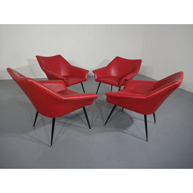 Set of 4 armchairs from the 1960s. Original cover with red imitation leather. Completely new upholstered. Legs in black...