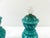 An elegant pair of large, covered turquoise blown glass jars, featuring a particularly decorative multi-layered...