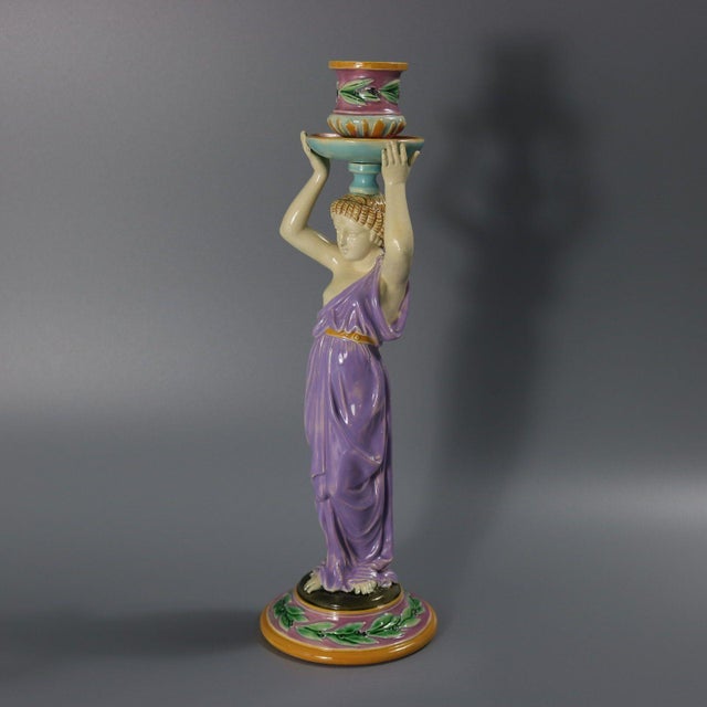 George Jones Majolica candlestick which features a lady dressed in a classical, flowing robe, holding the candle sconce...