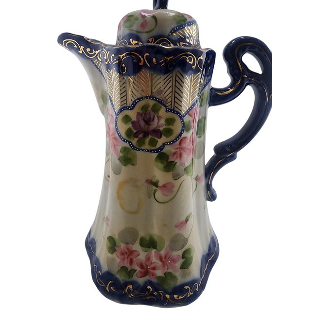 Antique porcelain hot chocolate pot featuring a delicate beaded overlay design and elegant silhouette. Measures...