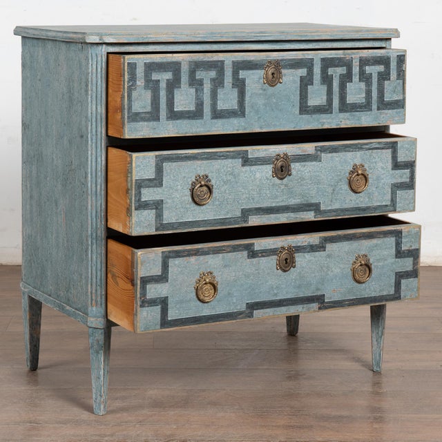 A decorative Gustavian style chest of drawers with canted fluted sides raised on tapered fluted feet. Three drawers...
