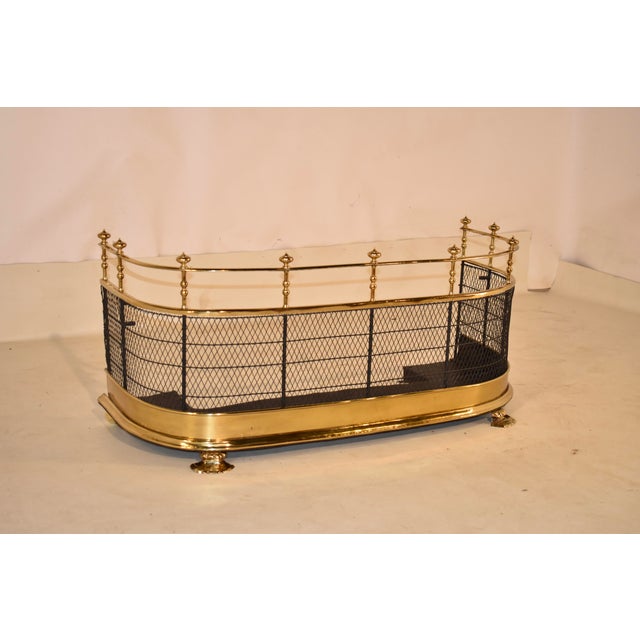 Early 19th century brass fire fender from England. The fender has a brass upper bar gallery with flanking ball finials,...