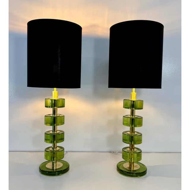 Elegant pair of table lamps produced in the early 2000s, featuring a refined composition of transparent green Murano glass...