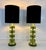 Elegant pair of table lamps produced in the early 2000s, featuring a refined composition of transparent green Murano glass...