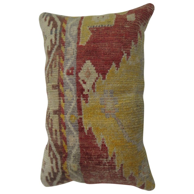 Lumbar size pillow made from a vintage Turkish Anatolian rug in accents of red, yellow, gray and brown. Size: 15” x 24”.