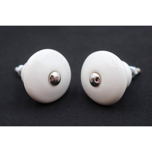 Vintage cabinet or drawer knobs made of white ceramic with a round shape. Mounting screws are included. Good condition...