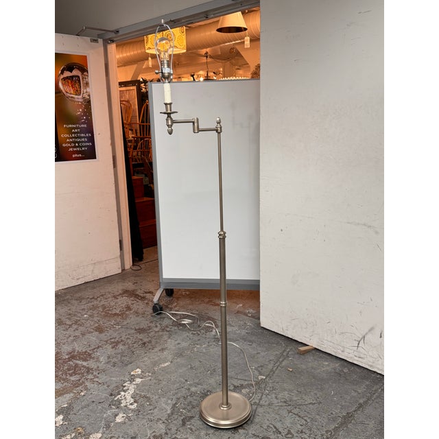 Design Plus Gallery presents a Transitional Brushed Nickel Swing Arm Floor Lamp. This lamp showcases classic library lamp...